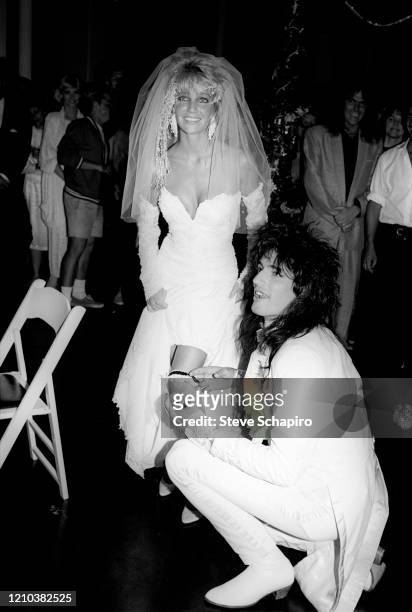 View of American actress Heather Locklear and musician Tommy Lee as the latter adjusts the former's garter during their wedding at the Santa Barbara...
