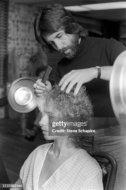 American hairdresser Jon Peters works on singer & actress Barbra Streisand's hair, Los Angeles, California, 1976.