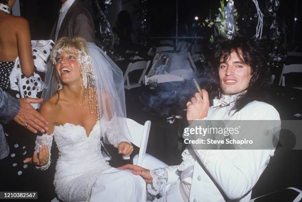 View of American actress Heather Locklear and musician Tommy Lee as they sit together during their wedding at the Santa Barbara Biltmore, Santa...