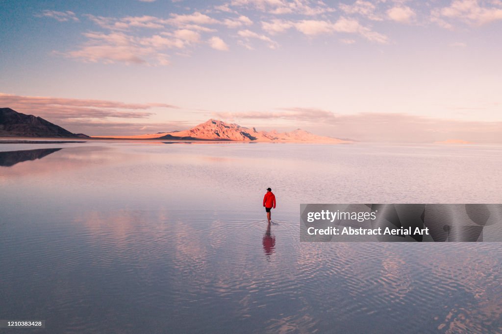 Aerial shot of a person walking across the flooded Bonneville salt flats, Utah, United States of America
