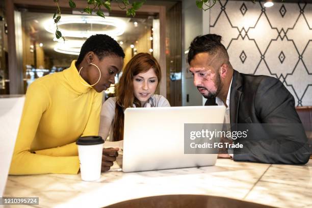 business partners using laptop on a meeting at coworking - vitiligo stock pictures, royalty-free photos & images