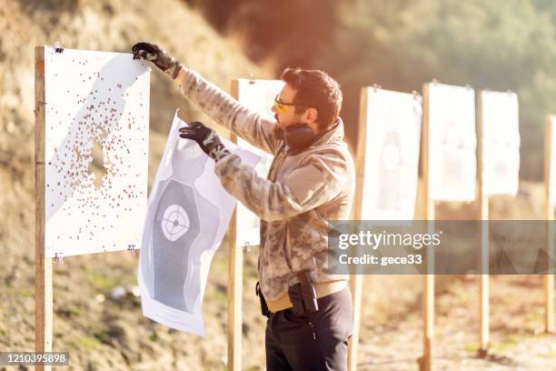 hombre cuelga objetivo - objetivo militar fotografías e imágenes de stock