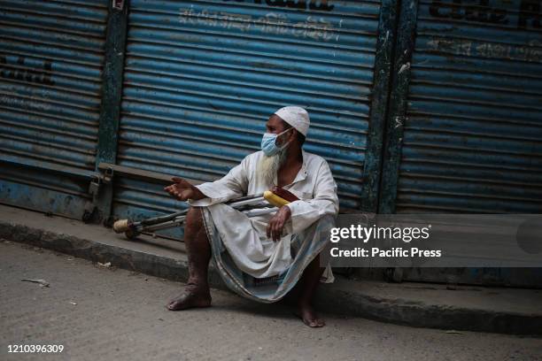 Street beggar wearing face mask in the street. In this health emergency situation, the most affected people are the homeless people and the beggars....