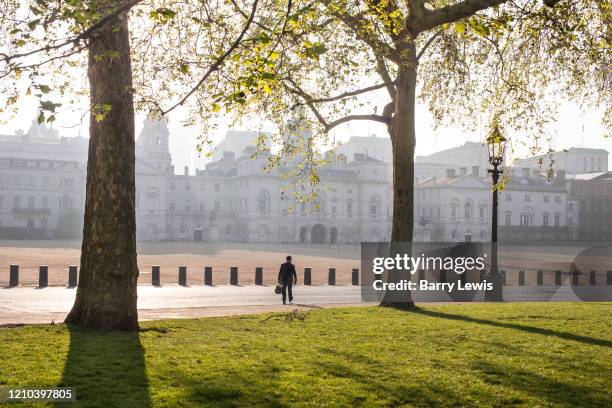 Lone walker crossing Horse Guards Parade from St James's Park on 16th April 2020 in London, United Kingdom. Normally crowded with people London is...