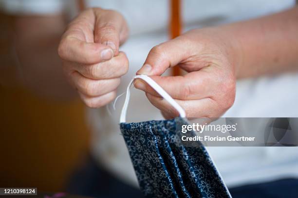 Woman sews a mouth protection on April 19, 2020 in Waldhufen, Germany. For monday on there is a requirement to wear mouth protection during shopping...