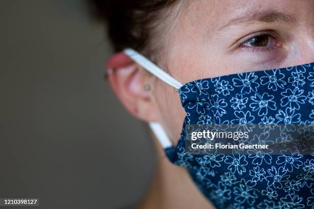 Woman wears a mouth protection on April 19, 2020 in Waldhufen, Germany. For monday on there is a requirement to wear mouth protection during shopping...