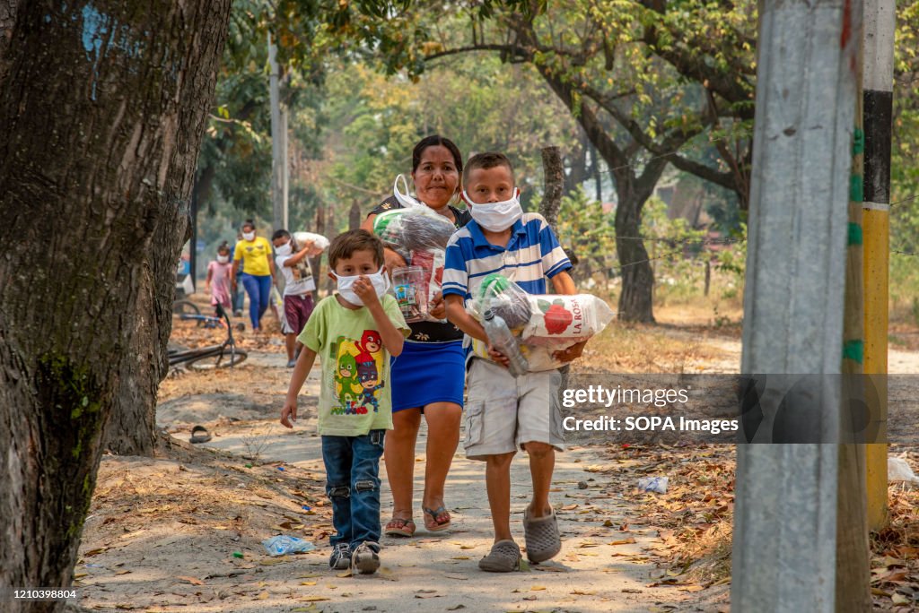 A family walk back home with bags of food that they received...