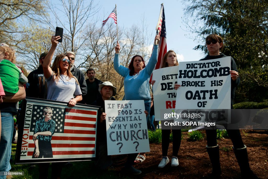 Protesters stand on the street while holding placards during...