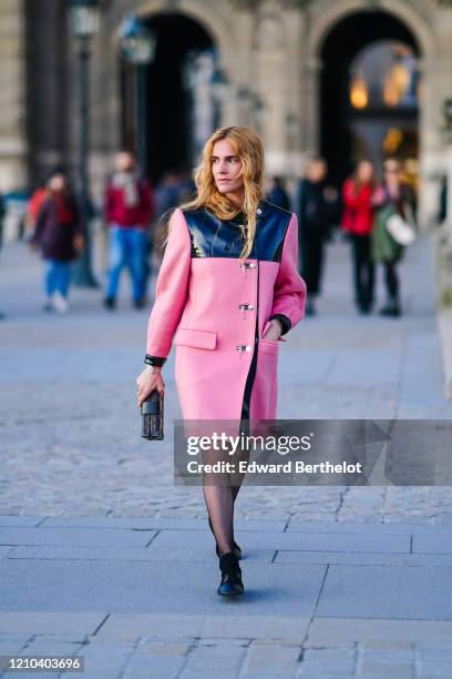 Blanca Miro wears a pink coat, a Vuitton monogram clutch, tights, black shoes, outside Vuitton, during Paris Fashion Week - Womenswear Fall/Winter...