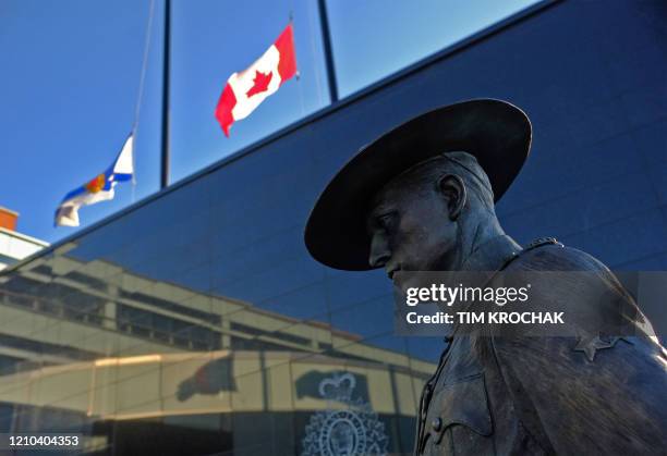 Flags of Nova Scotia and Canada fly at half-staff outside the Nova Scotia Royal Canadian Mounted Police headquarters in Dartmouth, Nova Scotia,...