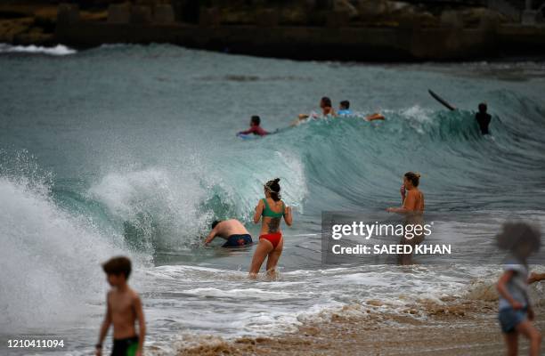 Residents swim at Coogee Beach in Sydney on April 20, 2020. - Authorities in Sydney reopened three beaches for walking, running, swimming or surfing...