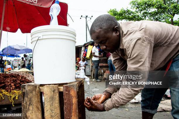 Man washes his hands with chlorinated water at the Mabibo market in Dar es Salaam, Tanzania, on April 16, 2020. - Tanzanian President John Magufuli...