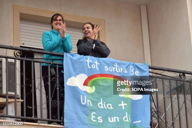 Mother and her daughter applaud from their balcony to show gratitude to the Covid-19 fighters during confinement. Neighbours from El vendrell city...