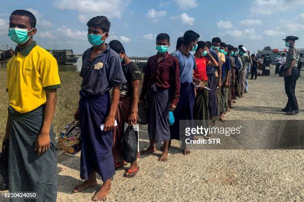 Released Rohingya prisoners wearing face masks amid concerns of the COVID-19 coronavirus pandemic arrive in Sittwe jetty in Rakhine State after being...