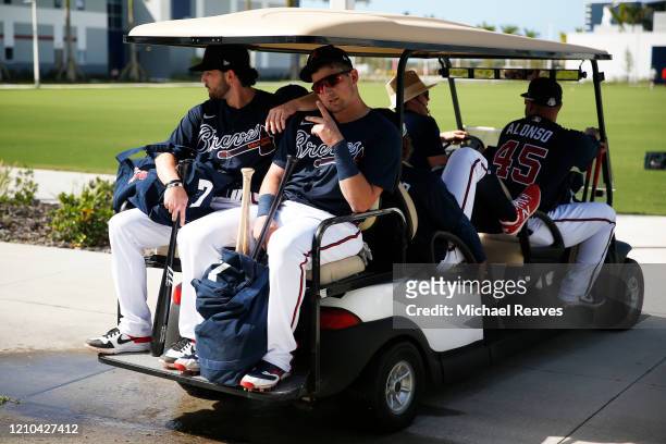 Dansby Swanson and Austin Riley of the Atlanta Braves take a golf cart to take batting practice during a team workout at CoolToday Park on February...