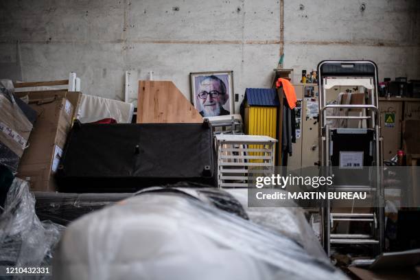 Picture taken on April 20, 2020 shows a picture of French Catholic Priest Abbe Pierre displayed in the second-hand shop of the Emmaus solidarity...