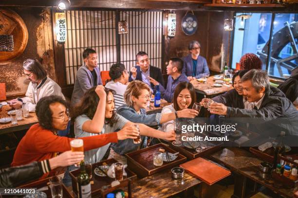 居酒屋で飲む多民族の友人のハイアングルビュー - 飲み会　日本 ストックフォトと画像
