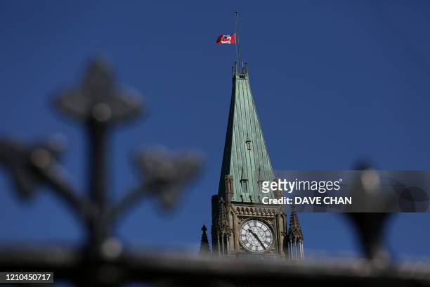 Canadian flag flies at half-mast on top of the Peace Tower to mourn the victims of the of the Nova Scotia shooting April 20, 2020 in Ottawa, Canada....