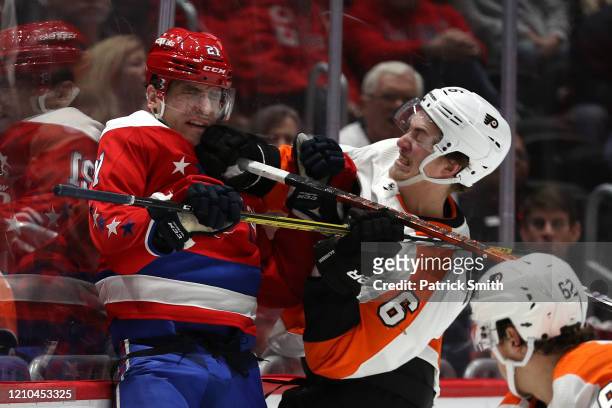 Garnet Hathaway of the Washington Capitals is checked by Travis Sanheim of the Philadelphia Flyers during the second period at Capital One Arena on...