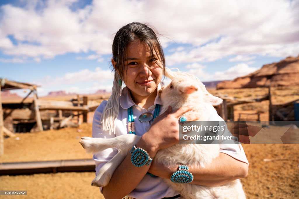 Closeup Of A Young Navajo Woman Holding A Lamb From The Flock