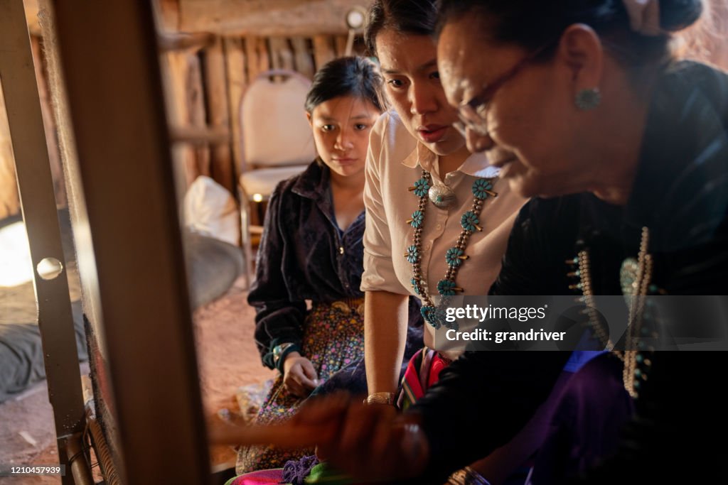 A Navajo Grandmother Teaching Her Young Granddaughters How To Weave On A Loom