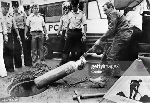Un policier retire une bouteille à oxygène des égouts de Nice le 20 juillet 1976. Suite au cambriolage de la Société Générale de Nice effectué par...