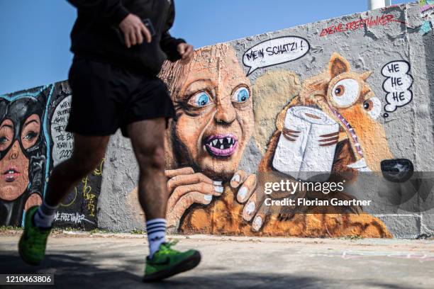 The movie characters Gollum and Scratch are pictured as a Graffiti with the topic of panic buying on April 20, 2020 in Berlin, Germany. Many people...