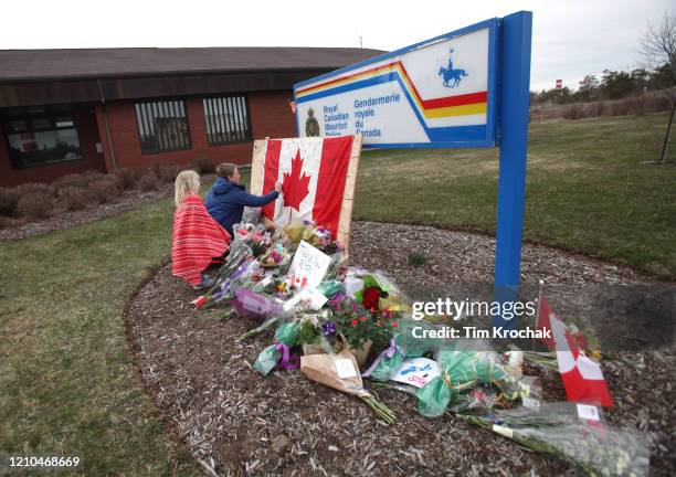 Children sign a Canadian flag at an impromptu memorial in front of the RCMP detachment April 20, 2020 in Enfield, Nova Scotia, Canada. It was the...