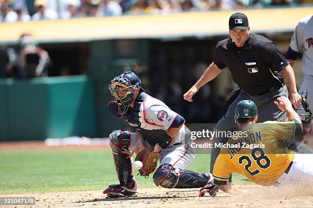 Conor Jackson of the Oakland Athletics slides safely into home during the game against the Minnesota Twins at the Oakland-Alameda County Coliseum on...