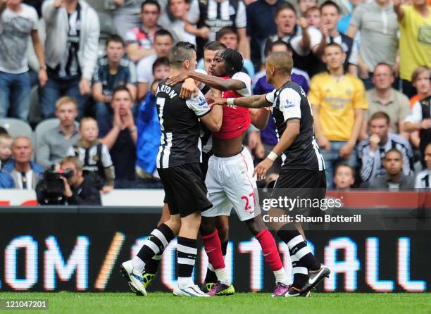 Gervinho of Arsenal confronts Joey Barton of Newcastle shortly before being shown the red card by referee Peter Walton during the Barclays Premier...