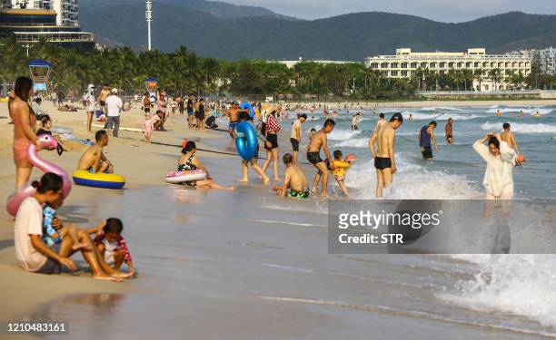 This photo taken on April 20, 2020 shows people enjoying the beach in Sanya in China's southern Hainan province. / China OUT