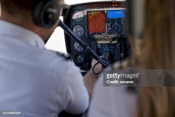 piloto de helicóptero y copiloto controlando los ajustes de los instrumentos de vuelo - co pilot fotografías e imágenes de stock