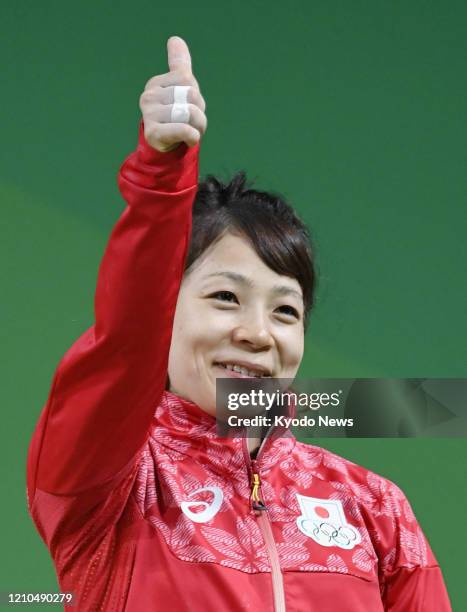 Photo taken Aug. 6 shows Japanese weightlifter Hiromi Miyake acknowledging spectators after winning bronze in the women's 48-kilogram category at the...