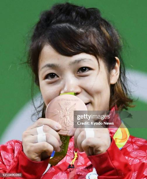 Photo taken Aug. 6 shows Japanese weightlifter Hiromi Miyake on the podium after winning bronze in the women's 48-kilogram category at the Rio de...