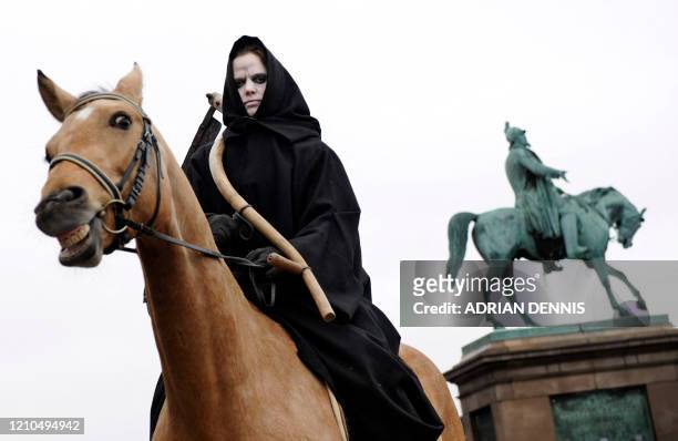 Woman dressed as "Death", of the Four Horsemen of the Apocalypse sits on a horse, during a Greenpeace demonstration in Parliament Square in...