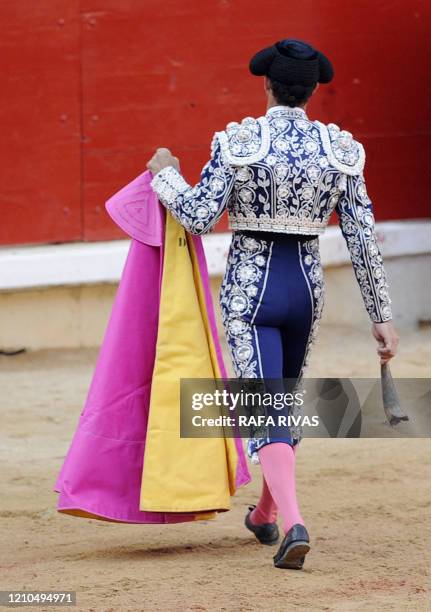 An assistant of French matador Sebastian Castella removes a broken horn of a Fuente Ymbro fighting bull during the third corrida of the San Fermin...