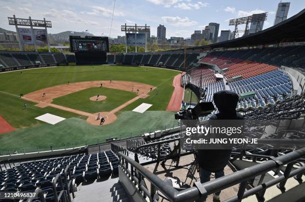 Cameraman records footage among empty stands during a pre-season baseball game between Seoul-based Doosan Bears and LG Twins at Jamsil stadium in...