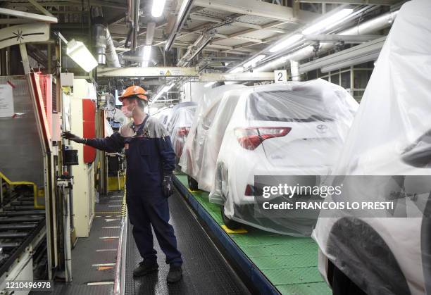 An employee of Toyota company works on an assembly line on April 21, 2020 in Onnaing, northern France, during the partial resume of the production at...