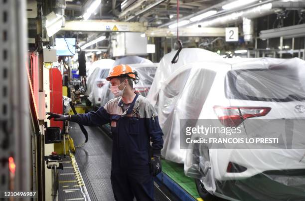 An employee of Toyota company works on an assembly line on April 21, 2020 in Onnaing, northern France, during the partial resume of the production at...