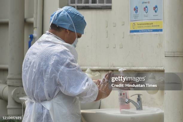 Medical worker washes hands before taking samples for antibody tests during the lockdown, at Belgachia bustee, on April 20, 2020 in Kolkata, India.