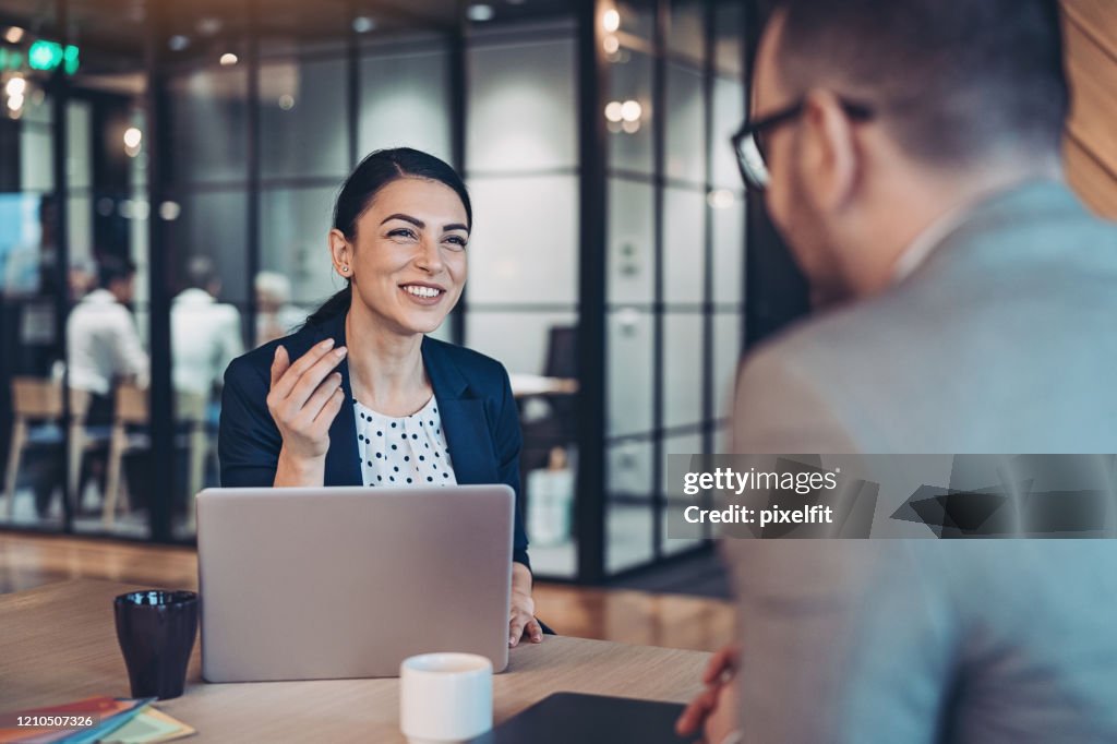 Smiling businesswoman talking to a colleague