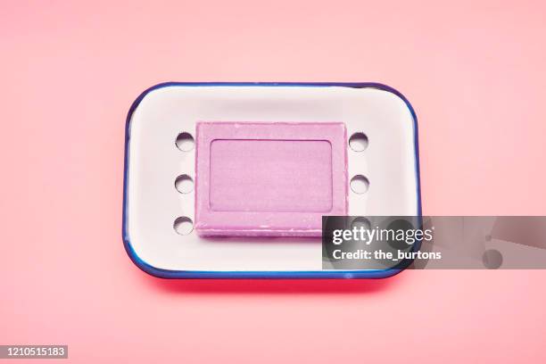 still life of an enamel soap dish and bar soap for washing hands on pink background - soap dish stock pictures, royalty-free photos & images