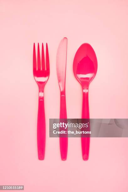 high angle view of pink plastic cutlery on pink background - disposable silverware stock pictures, royalty-free photos & images