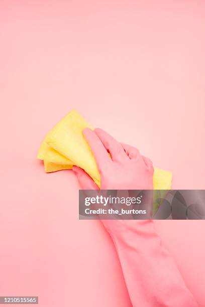 hand in pink glove with cleaning cloth on pink background, spring cleaning - rosa handschuh stock-fotos und bilder