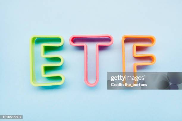 high angle view of etf letters on blue background, symbol of investment in stocks - etf fotografías e imágenes de stock