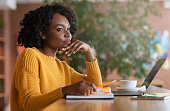 Thoughtful afro woman looking for new job online