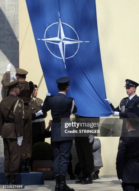 Croatian soldiers raise a newly made NATO flag in front of Croatian Defence Ministry in Zagreb on April 7, 2009. Croatia marked its accession to the...