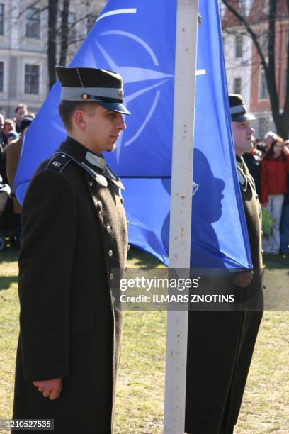 Latvian officers stand guard during the NATO flag rising ceremony in front of the Presidents castle in Riga 02 April 2004. Bulgaria, Estonia, Latvia,...