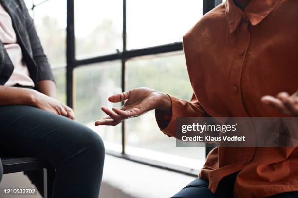 businesswoman gesturing by window at workplace - indicating ストックフォトと画像