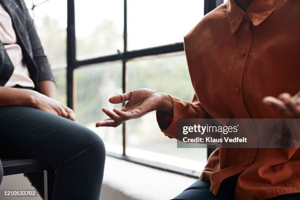 businesswoman gesturing by window at workplace - african hand gestures stock pictures, royalty-free photos & images